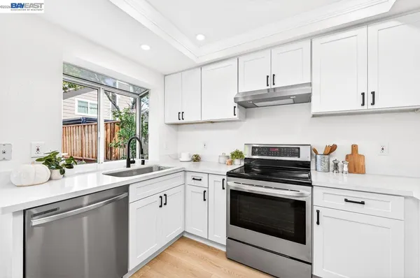 a kitchen with cabinets appliances a sink and a window