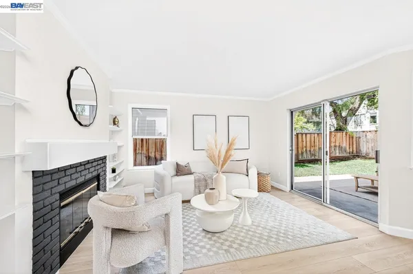 a living room with furniture a fireplace and a floor to ceiling window