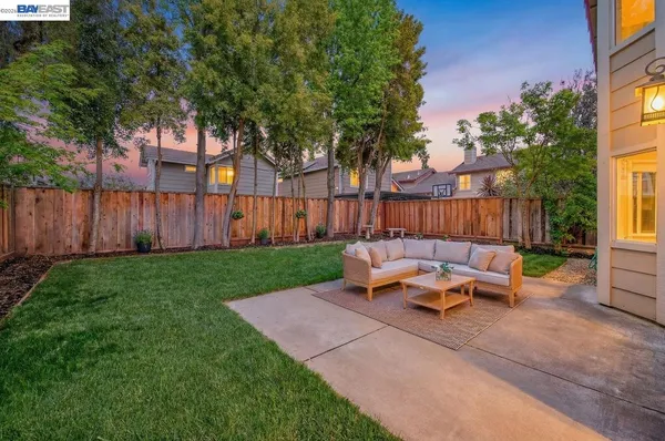 a view of a patio with table and chairs and wooden fence