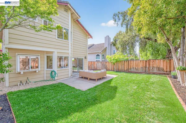 a view of a chair and table in backyard of the house