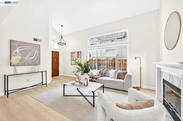 a living room with furniture a fireplace and a chandelier