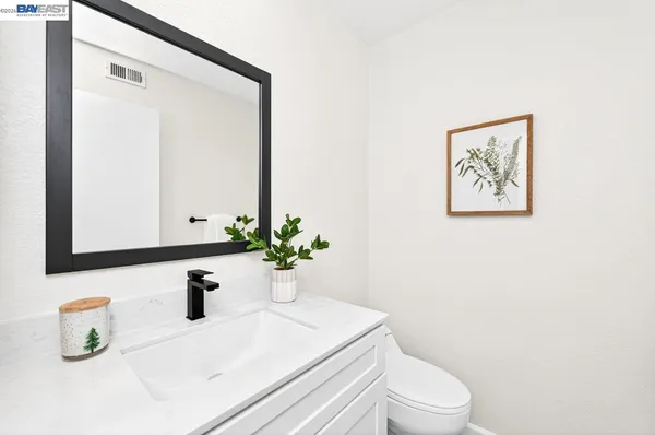 a bathroom with a sink a toilet and mirror