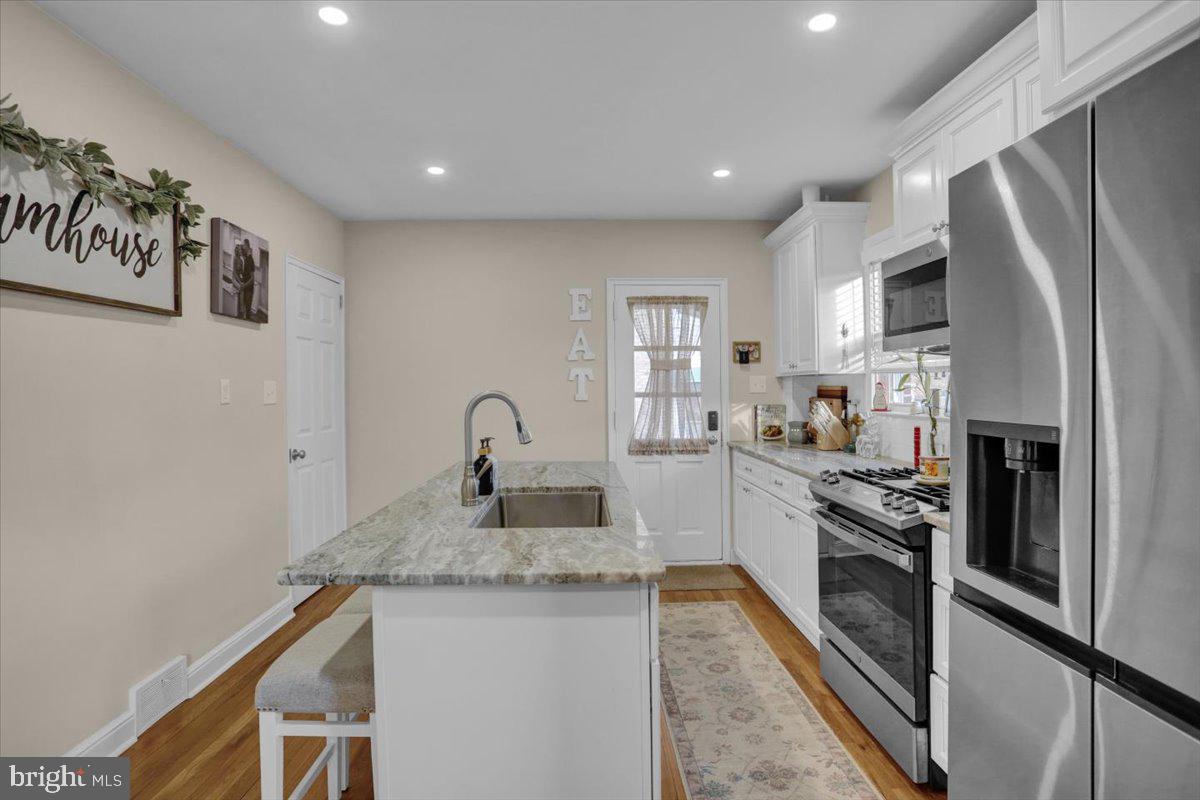 321 Jefferson Boulevard Reading, PA 19609 - Photo 9 of 32 a kitchen with stainless steel appliances granite countertop a refrigerator a stove and a sink with wooden floor