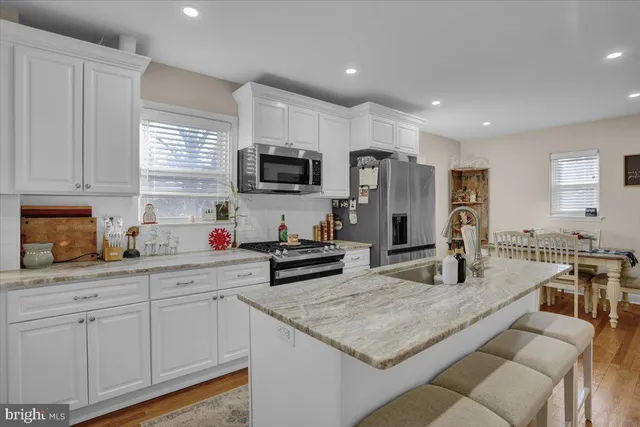 a view of a dining room with furniture a rug and wooden floor
