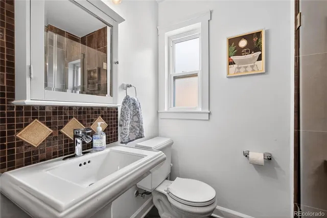 a bathroom with a sink a toilet and mirror