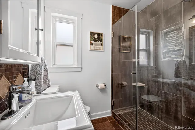 a bathroom with a sink a toilet and a shower