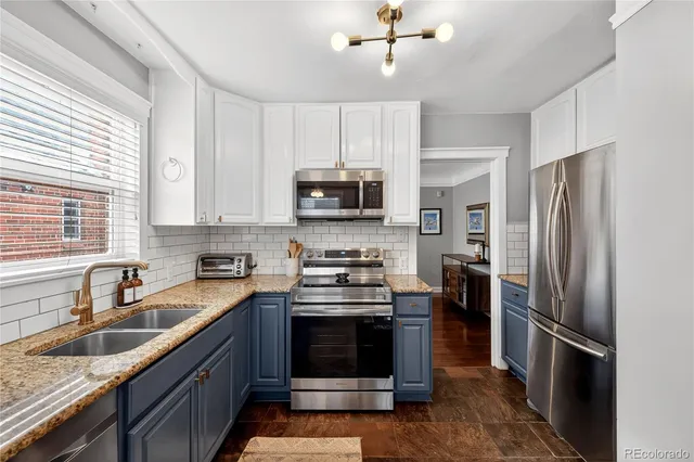 a kitchen with kitchen island granite countertop a stove sink microwave and refrigerator