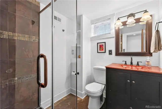 a bathroom with a toilet sink shower and mirror