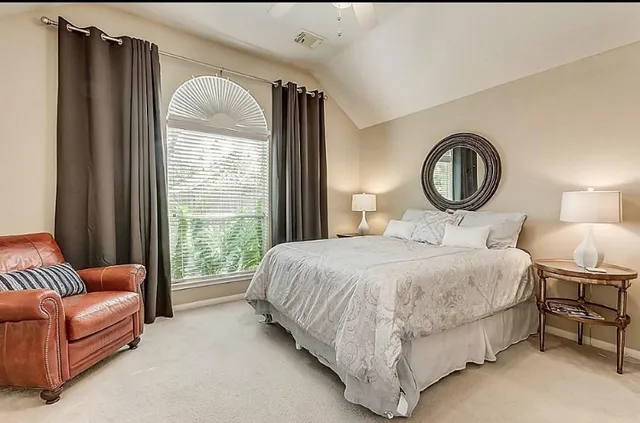 a bedroom with a bed couch and window