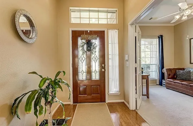 a view of a hallway with wooden floor and a potted plant