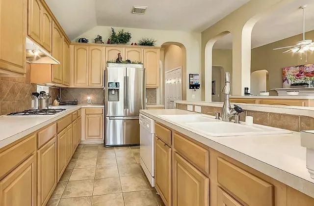 a kitchen with stainless steel appliances a sink and a refrigerator
