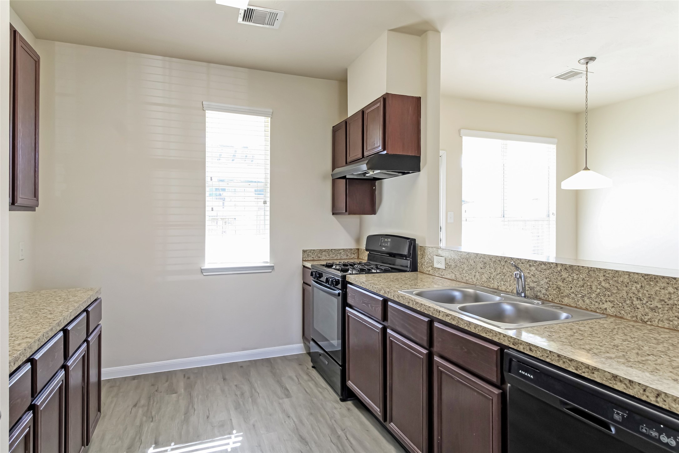 12406 Roy Mix Bohn Lane Houston, TX 77044 - Photo 4 of 16 a kitchen with a sink stove top oven and cabinets