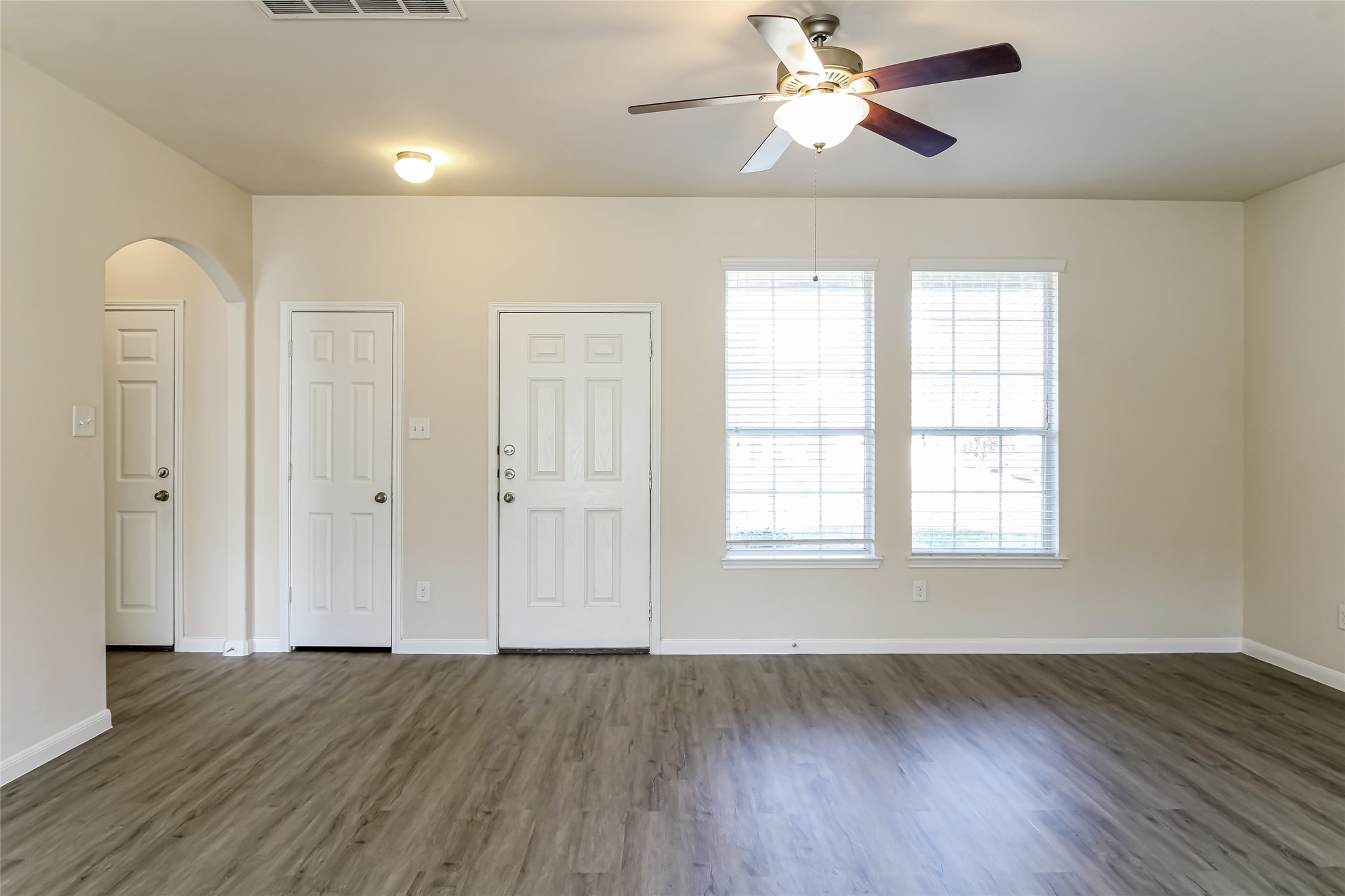 12406 Roy Mix Bohn Lane Houston, TX 77044 - Photo 9 of 16 an empty room with wooden floor chandelier fan and windows