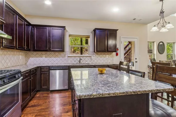 a kitchen with a stove a refrigerator and a dining table
