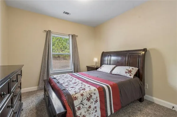 a bedroom with a bed and a dresser with mirror