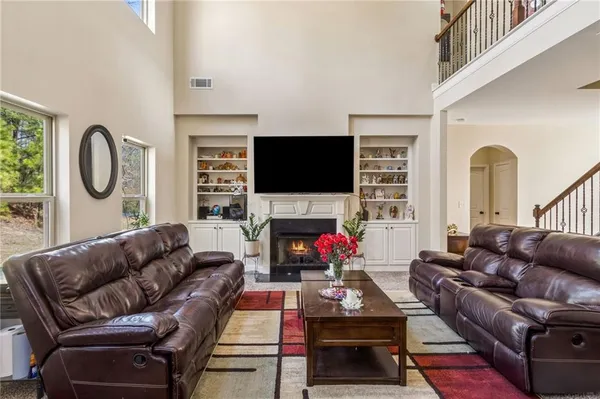 a living room with furniture a flat screen tv and a fireplace