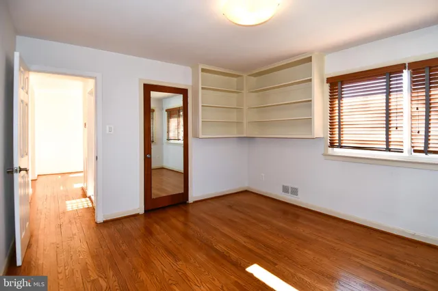 a view of empty room with wooden floor