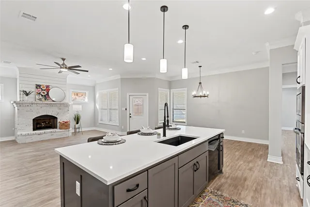 a kitchen with a sink a stove and a wooden floor