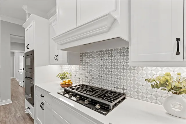 a kitchen with a stove and a white wooden cabinets