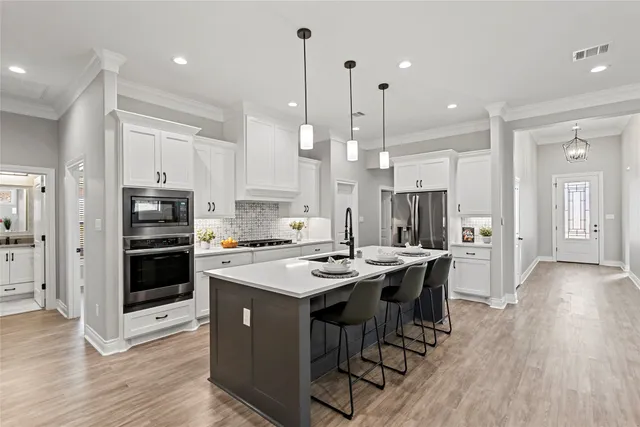 a kitchen with stainless steel appliances a stove a sink a center island and a refrigerator