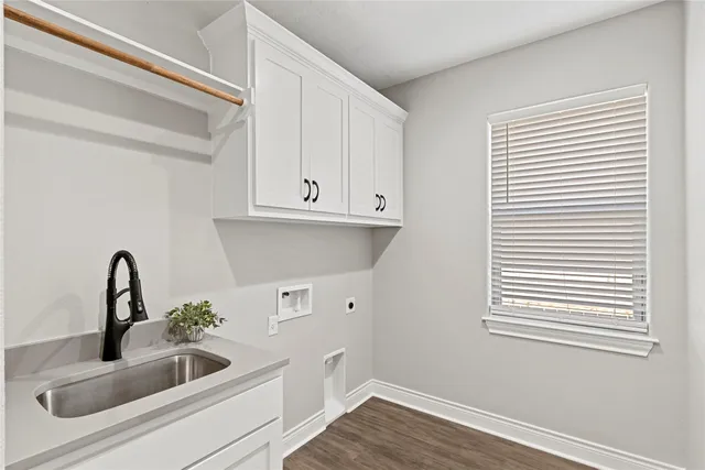 a kitchen with a sink and wooden floor