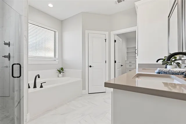 a bathroom with a tub sink and mirror