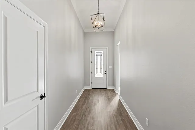a view of a hallway with wooden floor and a window