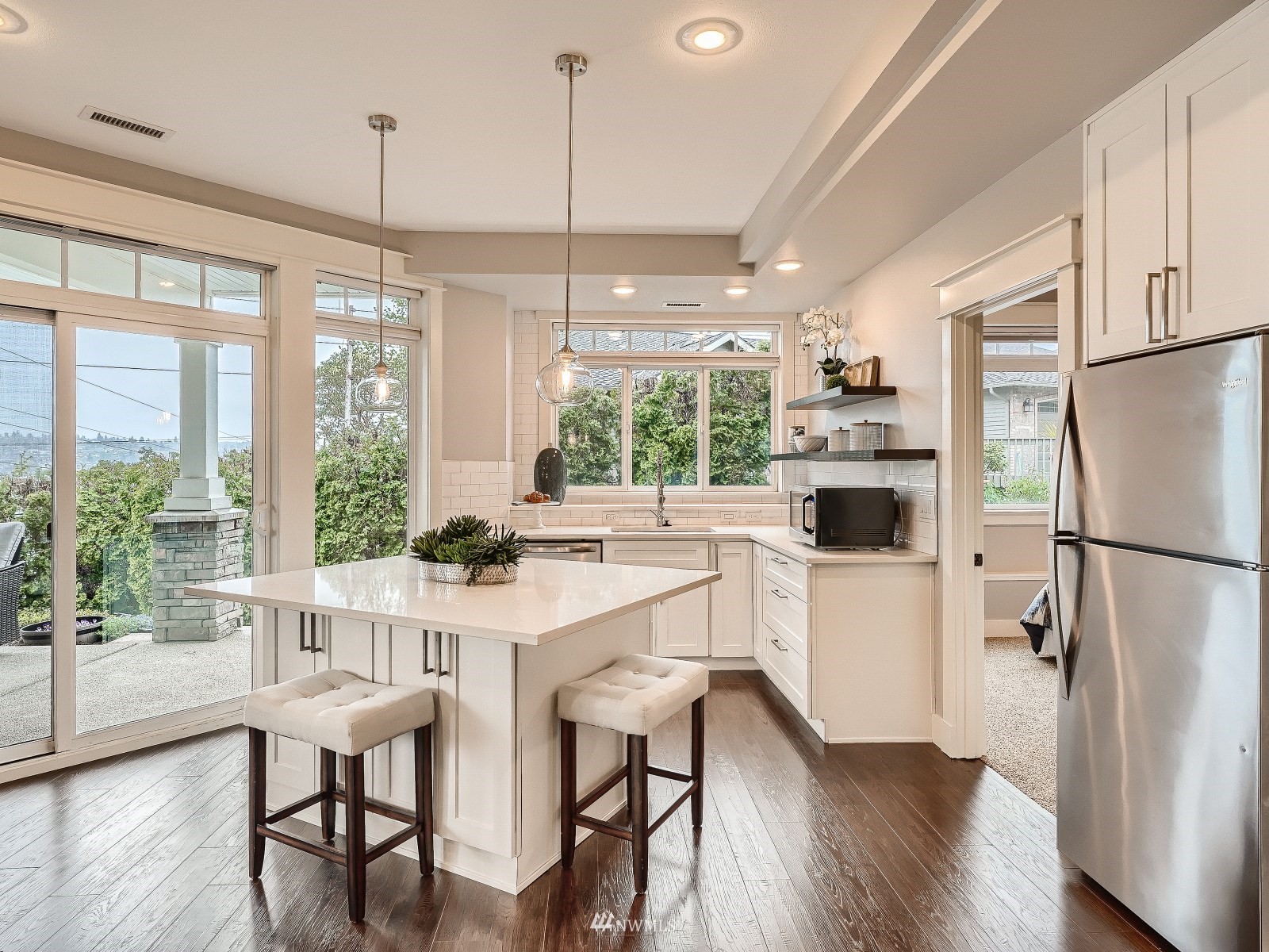 706 North 29th Street Renton, WA 98056 - Photo 30 of 37 a kitchen with stainless steel appliances a dining table chairs refrigerator and wooden floor