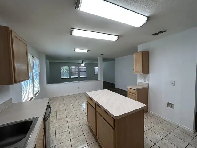 a large white kitchen with a stove a sink dishwasher and a refrigerator