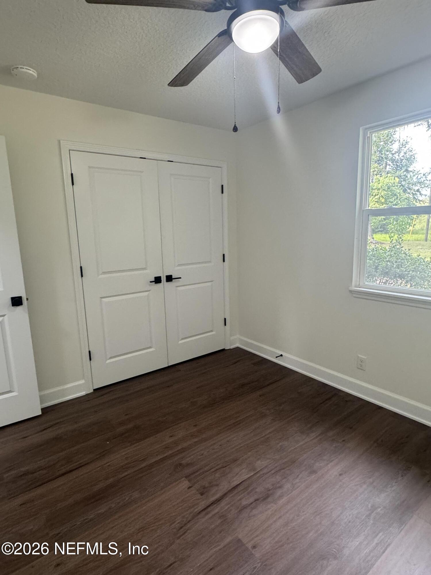 5202 Southwest 155th Street Starke, FL 32091 - Photo 12 of 13 an empty room with wooden floor and windows