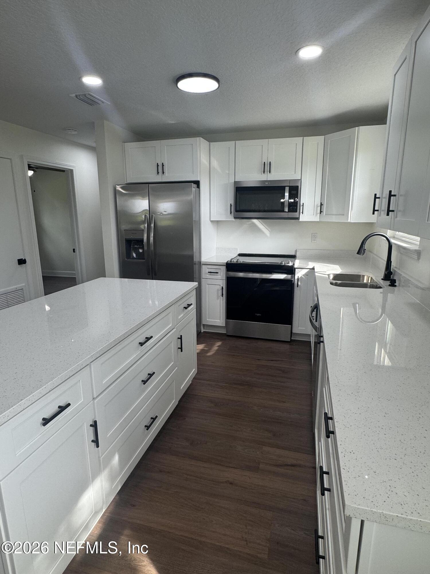 5202 Southwest 155th Street Starke, FL 32091 - Photo 3 of 13 a large kitchen with cabinets and stainless steel appliances