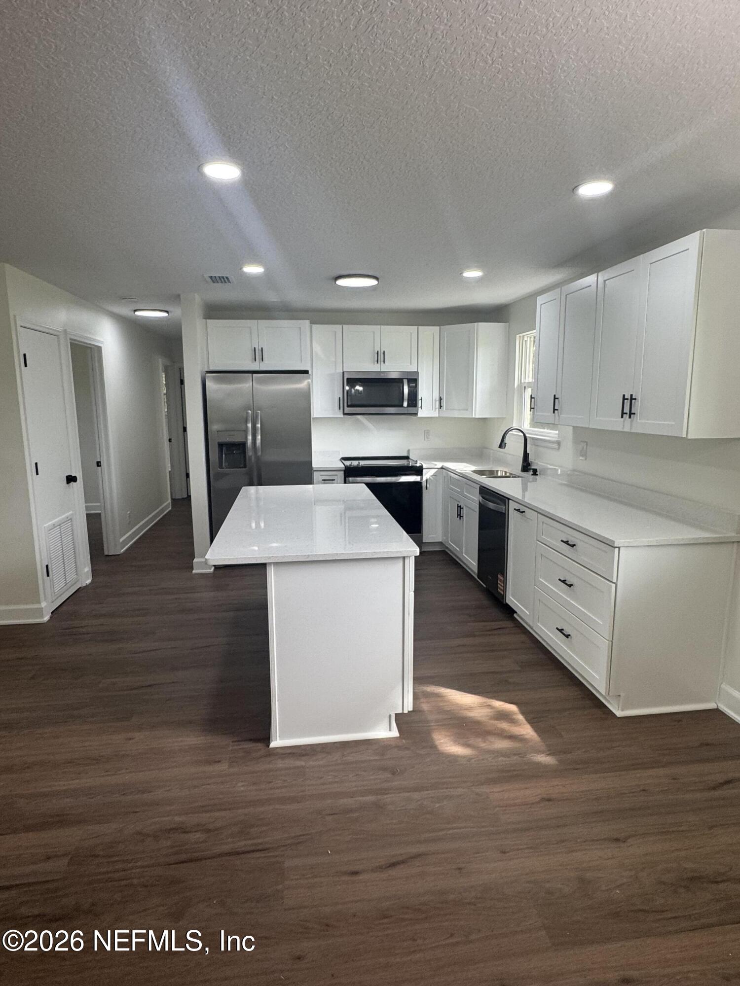 5202 Southwest 155th Street Starke, FL 32091 - Photo 4 of 13 a kitchen with a stove a sink and a refrigerator