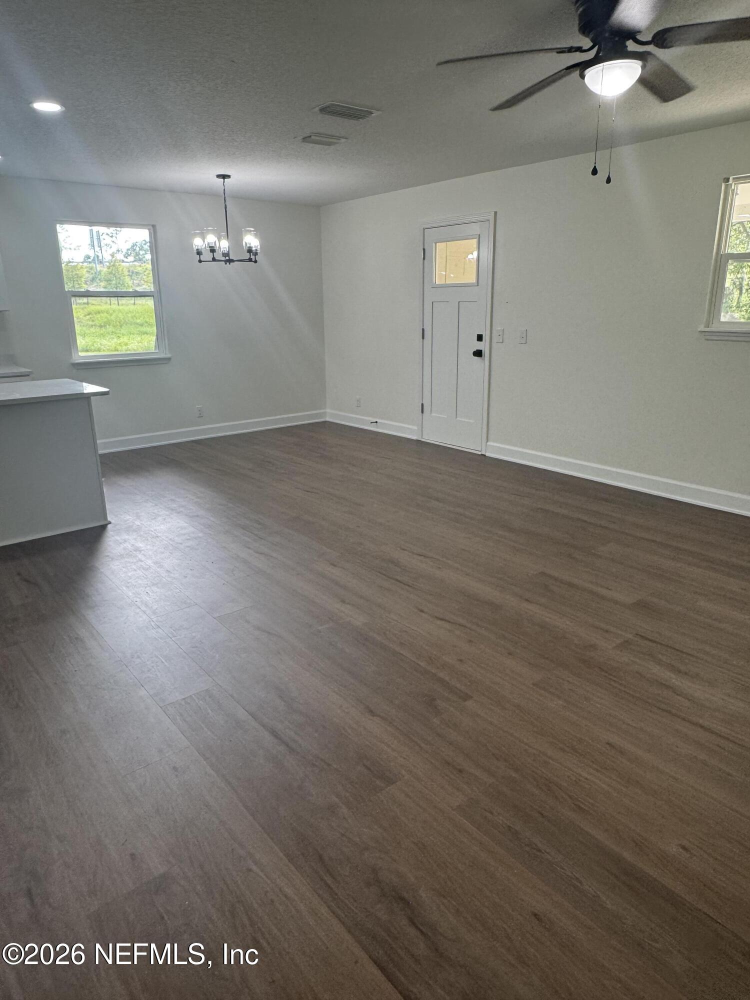 5202 Southwest 155th Street Starke, FL 32091 - Photo 6 of 13 an empty room with wooden floor and windows