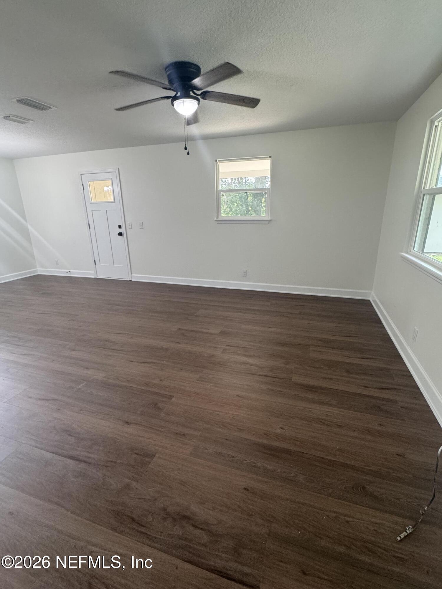 5202 Southwest 155th Street Starke, FL 32091 - Photo 7 of 13 an empty room with wooden floor fan and windows