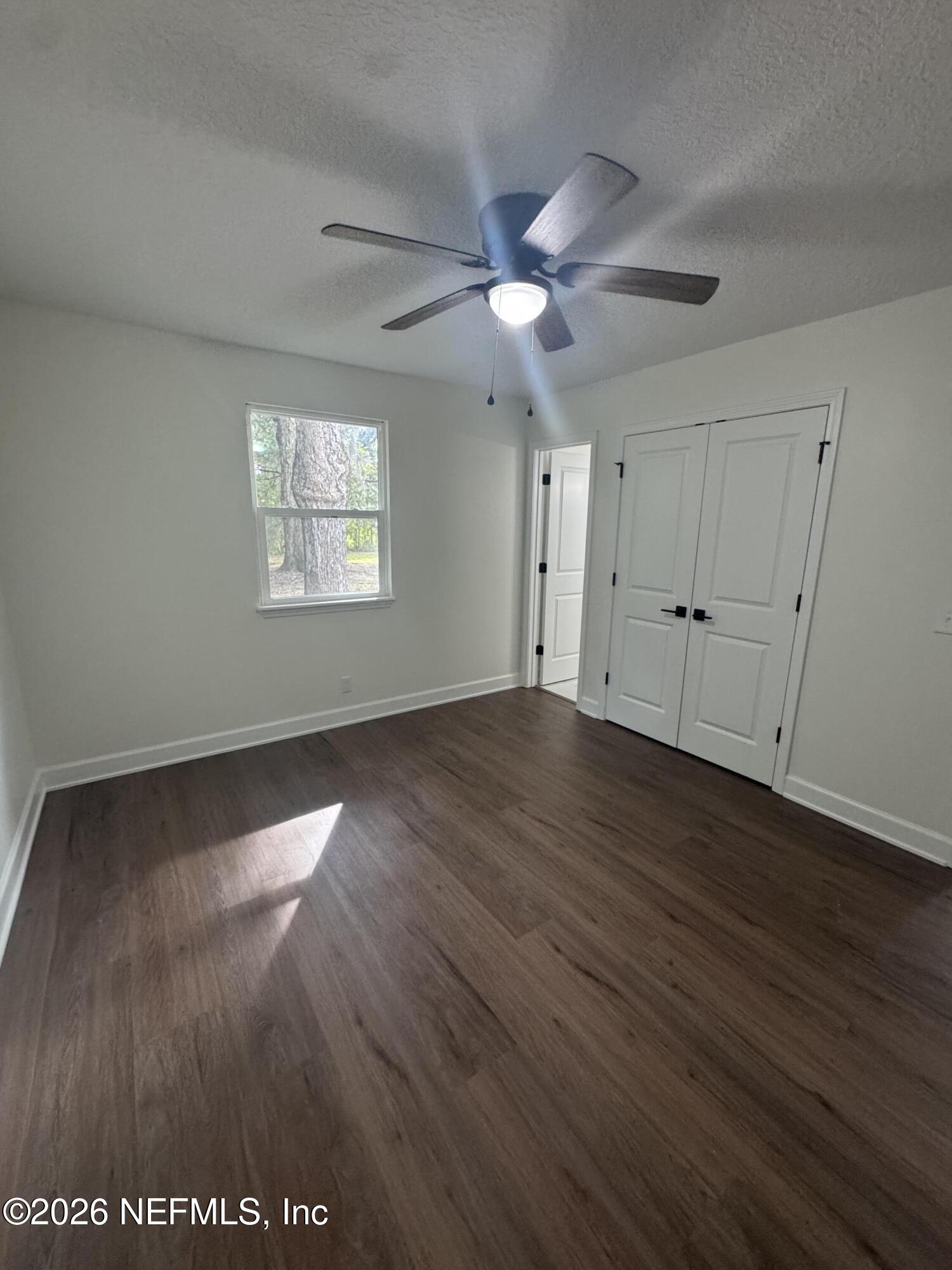 5202 Southwest 155th Street Starke, FL 32091 - Photo 9 of 13 wooden floor in an empty room with a window