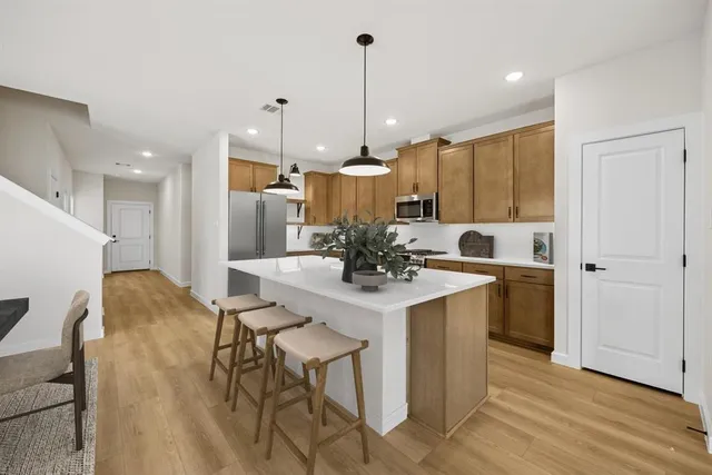 a kitchen with kitchen island a sink stove and refrigerator