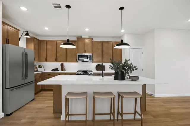 a kitchen with kitchen island a stove a chandelier and refrigerator