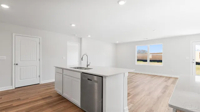 a kitchen with a sink cabinets and wooden floor
