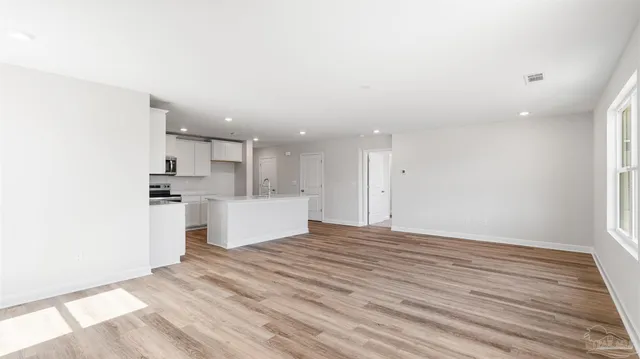 a view of kitchen with kitchen island white cabinets and wooden floor