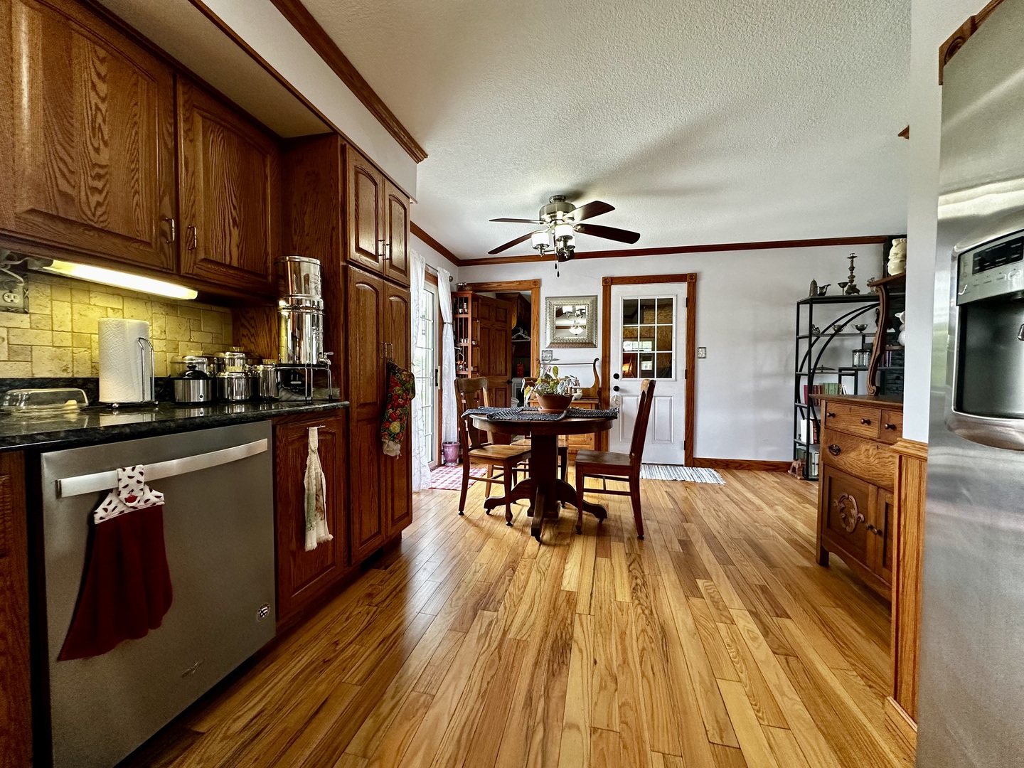 6119 Little Galilee Road Clinton, IL 61727 - Photo 14 of 26 a open kitchen with stainless steel appliances granite countertop a refrigerator a stove top oven a dining table and chairs with wooden floor