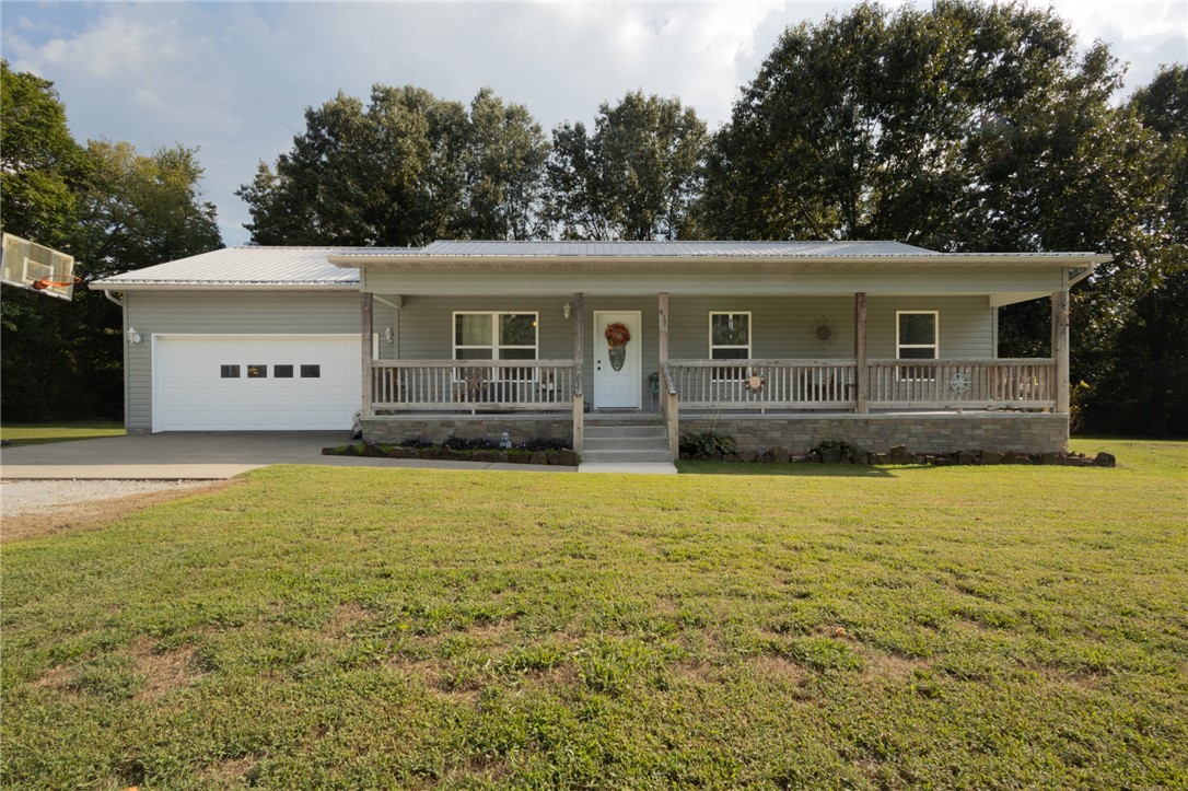 437 Gip Annie Road West Harrison, AR 72601 - Photo 1 of 21 Siding exterior with a covered porch, white entry door, attached garage, and metal roof