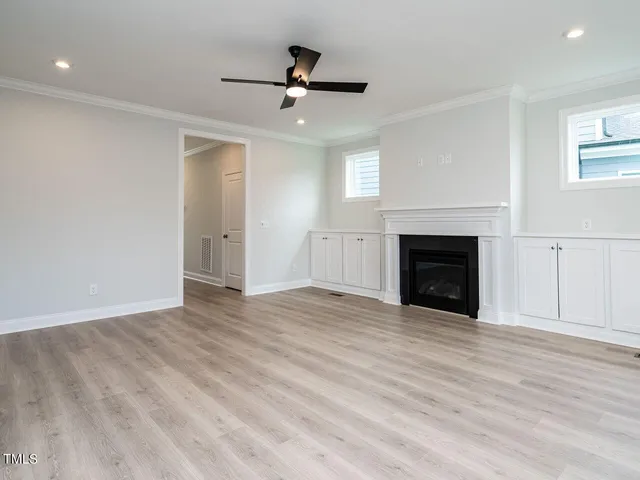a view of empty room with wooden floor and fireplace