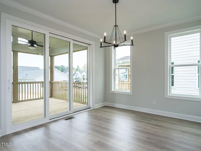 a view of empty room with wooden floor and windows