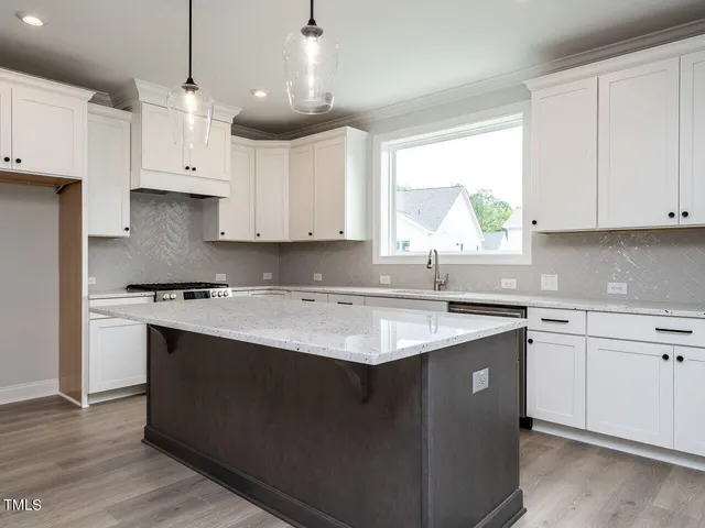 a kitchen with stainless steel appliances granite countertop a sink a stove and a refrigerator