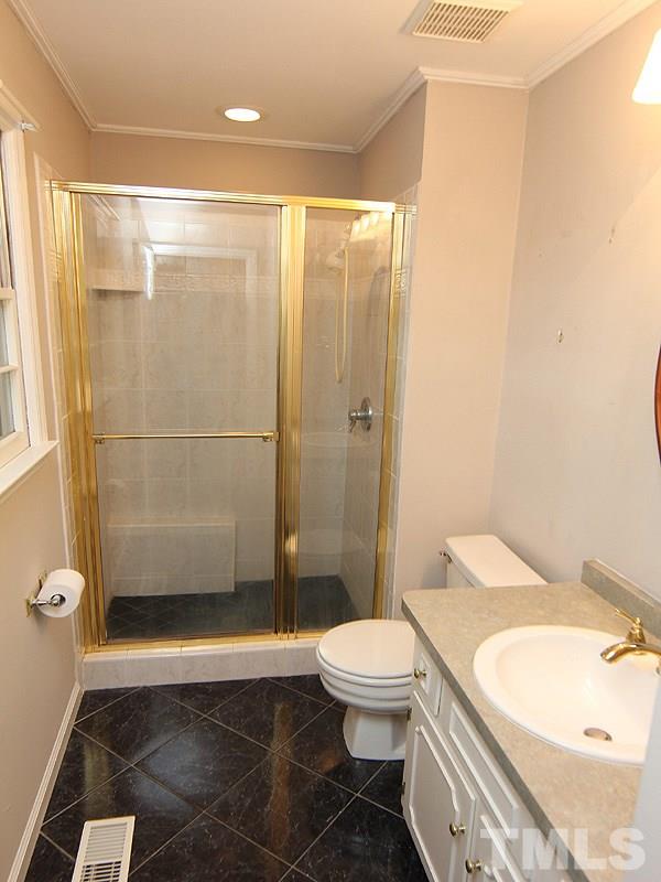 6416 Wynbrook Way Raleigh, NC 27612 - Photo 8 of 13 a bathroom with a toilet a sink and shower