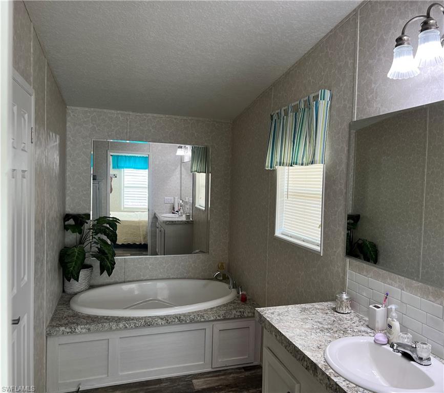 6 Cannes Drive Naples, FL 34112 - Photo 14 of 21 a bathroom with a granite countertop sink and a mirror