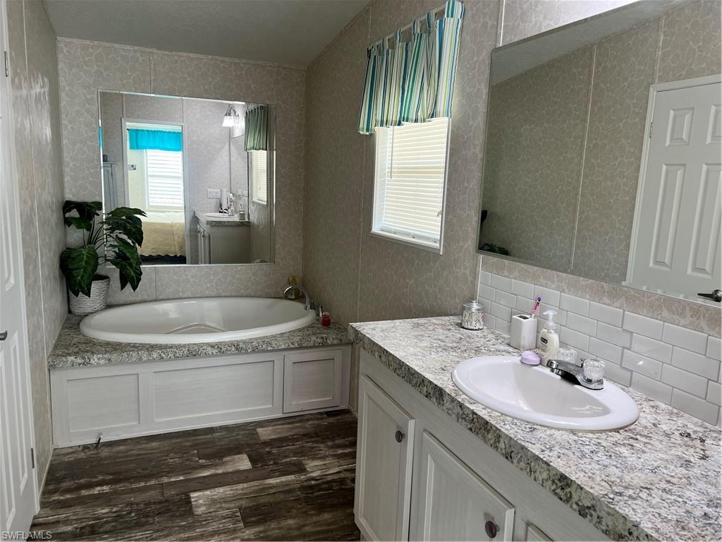6 Cannes Drive Naples, FL 34112 - Photo 15 of 21 a bathroom with granite countertop a sink and a mirror