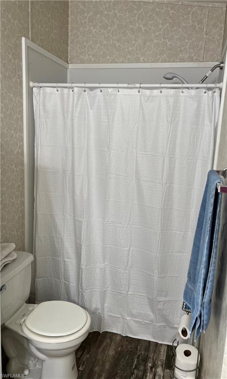 6 Cannes Drive Naples, FL 34112 - Photo 16 of 21 a white toilet sitting next to a shower curtain