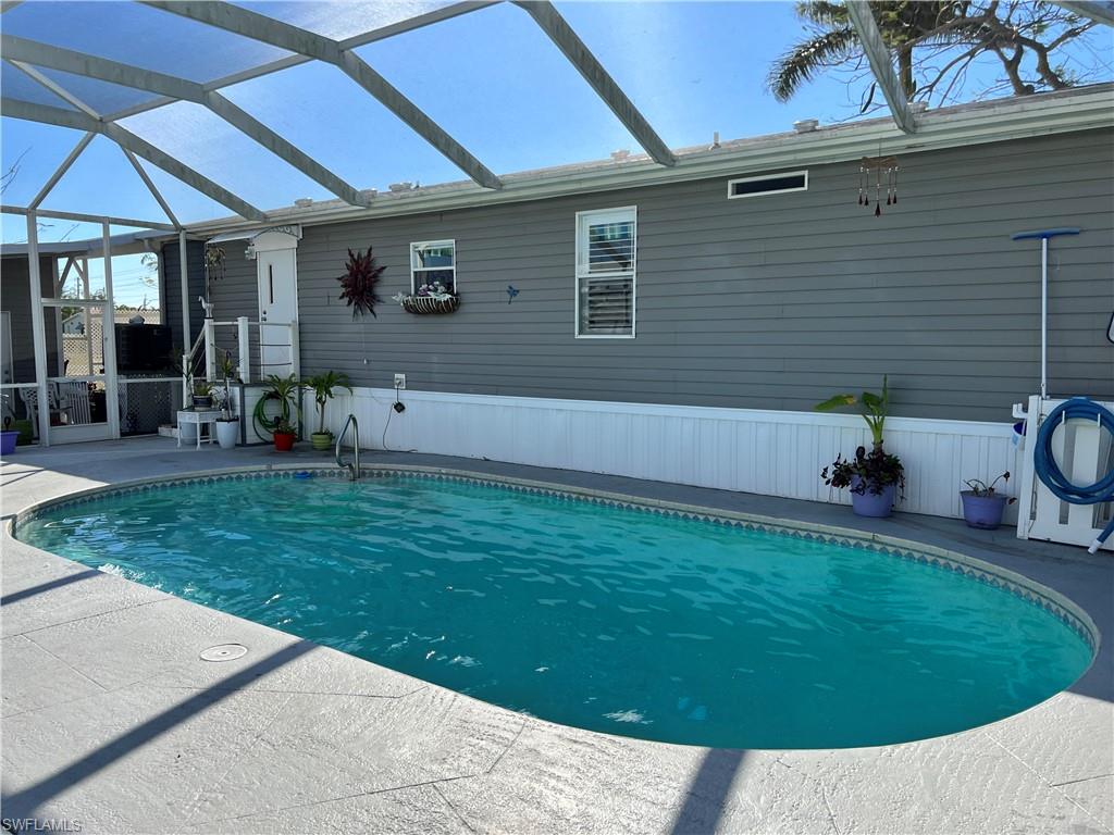 6 Cannes Drive Naples, FL 34112 - Photo 19 of 21 a view of a backyard with table and chairs