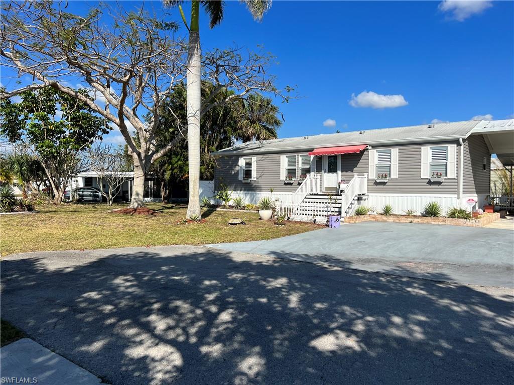 6 Cannes Drive Naples, FL 34112 - Photo 2 of 21 a front view of a house with a yard